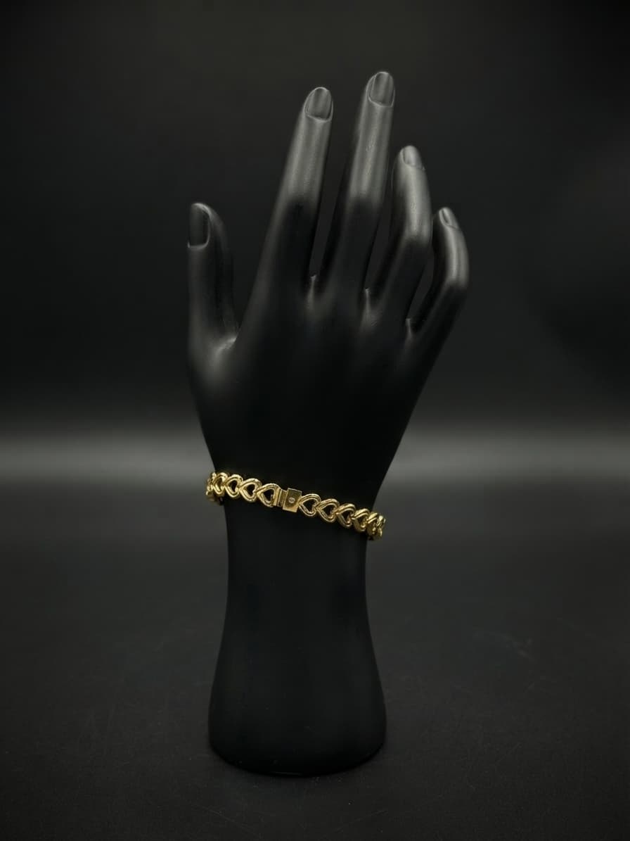 Pulsera mediana de acero ondulada color dorado corazones